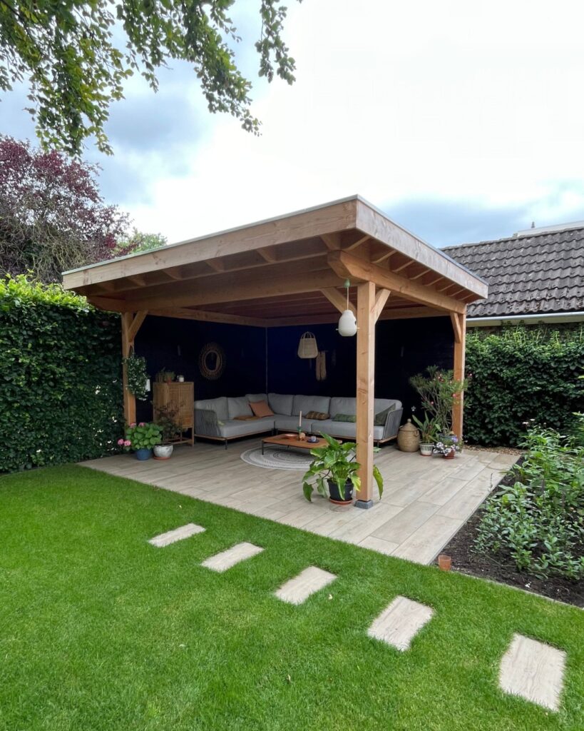 Luxe overkapping in en modern aangelegde tuin met een zachtgrijze loungeset